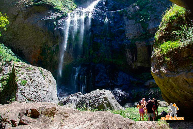 Persona Debajo de una Piedra al Fondo la Cascada Salto de Quintanilla Zacapoaxtla De Mochilazo